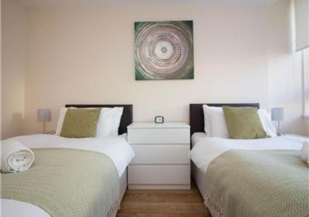 a bedroom with two beds and a picture on the wall at StayZo Stylish Accommodation in Southampton 10 in Southampton