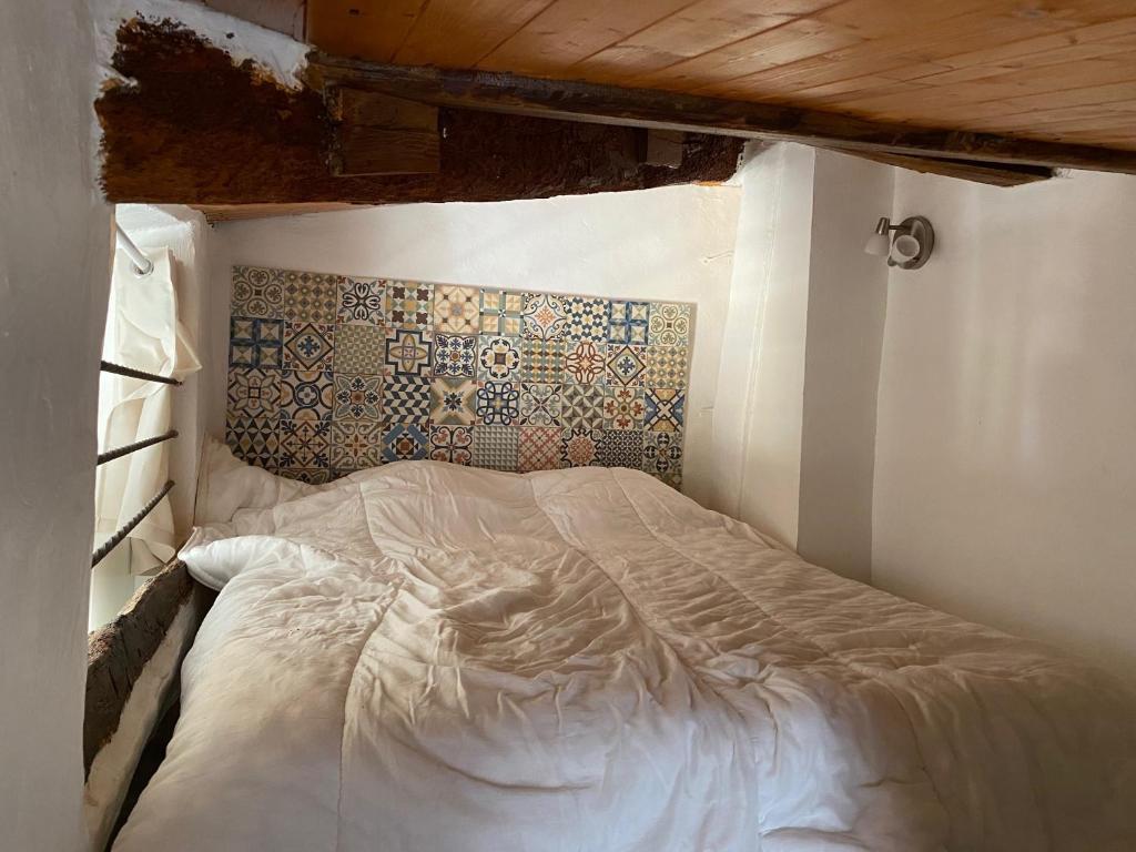 a white bed in a room with a wall at Studios des Templiers in Hyères