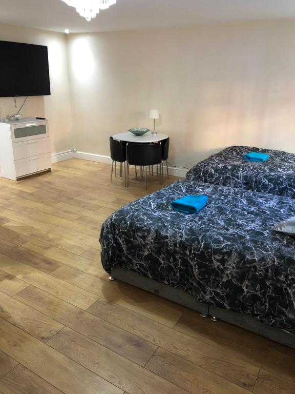 a bedroom with a bed and a table with chairs at BIG ROOM rusholme WITH TV AND PRIVATE BATHROOM-parking&wifi in Manchester