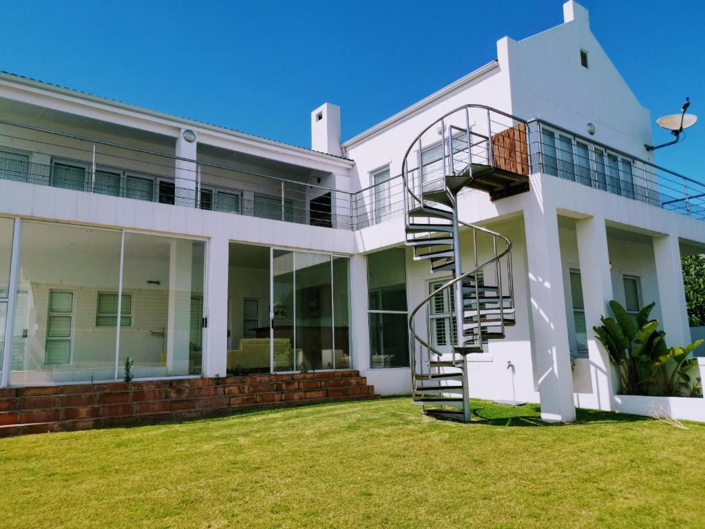 uma casa branca com uma escada em espiral em Villa Royale em St Helena Bay