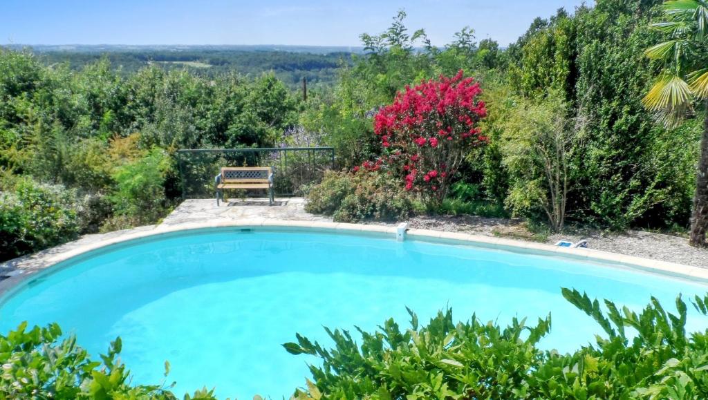 a pool in a garden with a bench and flowers at Maison de 2 chambres avec piscine privee jardin amenage et wifi a Bruniquel in Bruniquel