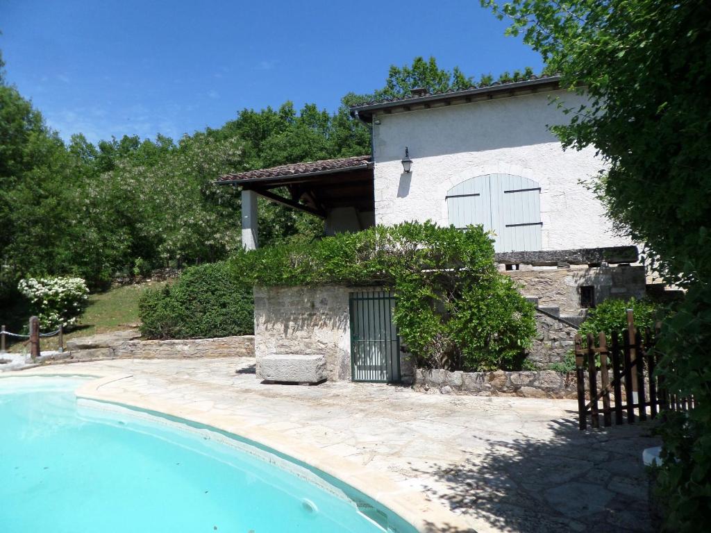 a house and a swimming pool in front of a house at Maison de 2 chambres avec piscine privee jardin amenage et wifi a Bruniquel in Bruniquel