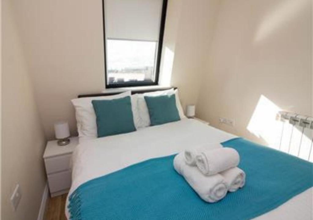 a bedroom with a bed with towels on it at StayZo Premiere Serviced Accommodation-17 in Southampton