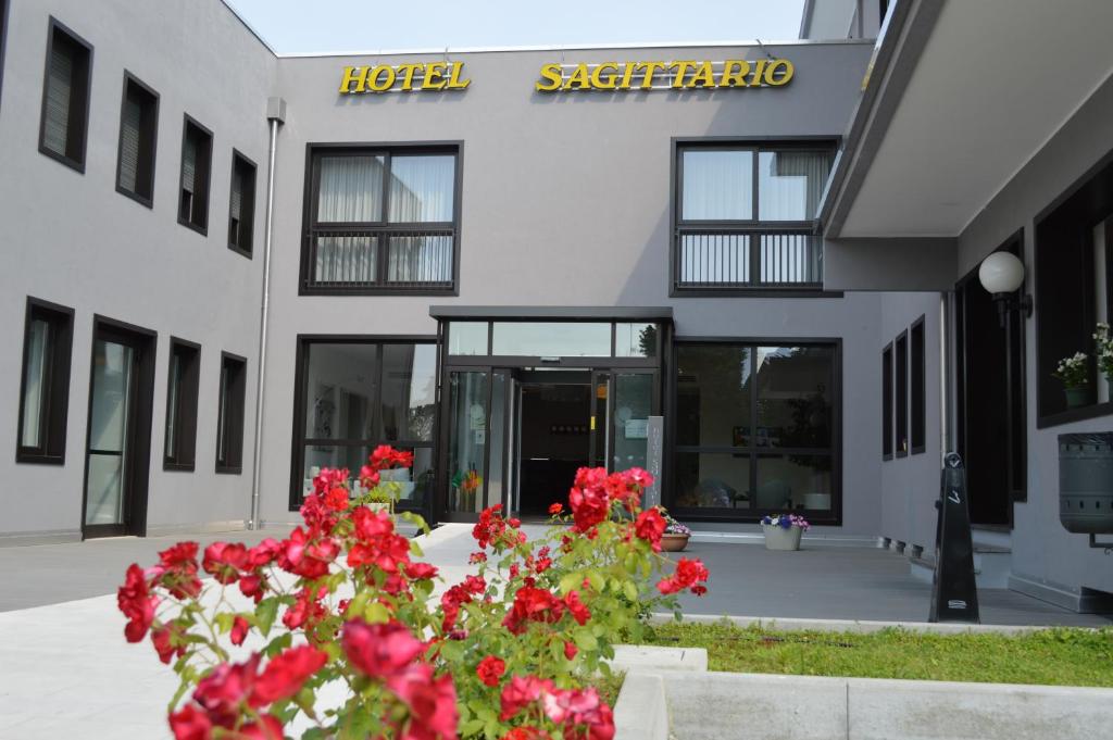 een gebouw met rode bloemen ervoor bij Hotel Sagittario in Padua