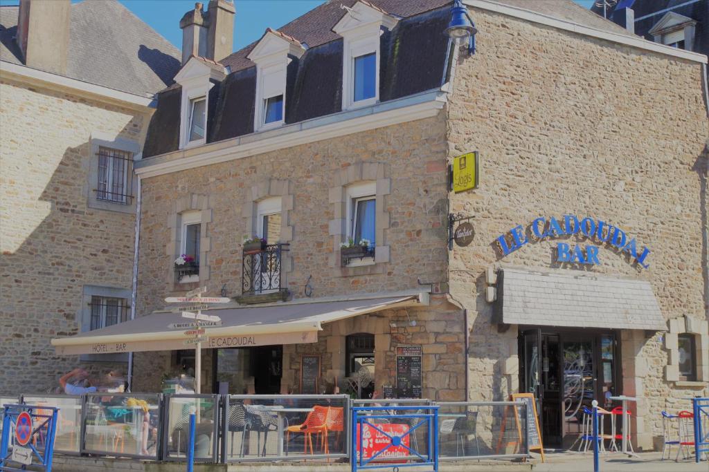 ein großes Backsteingebäude mit einem Restaurant davor in der Unterkunft Le Cadoudal in Auray