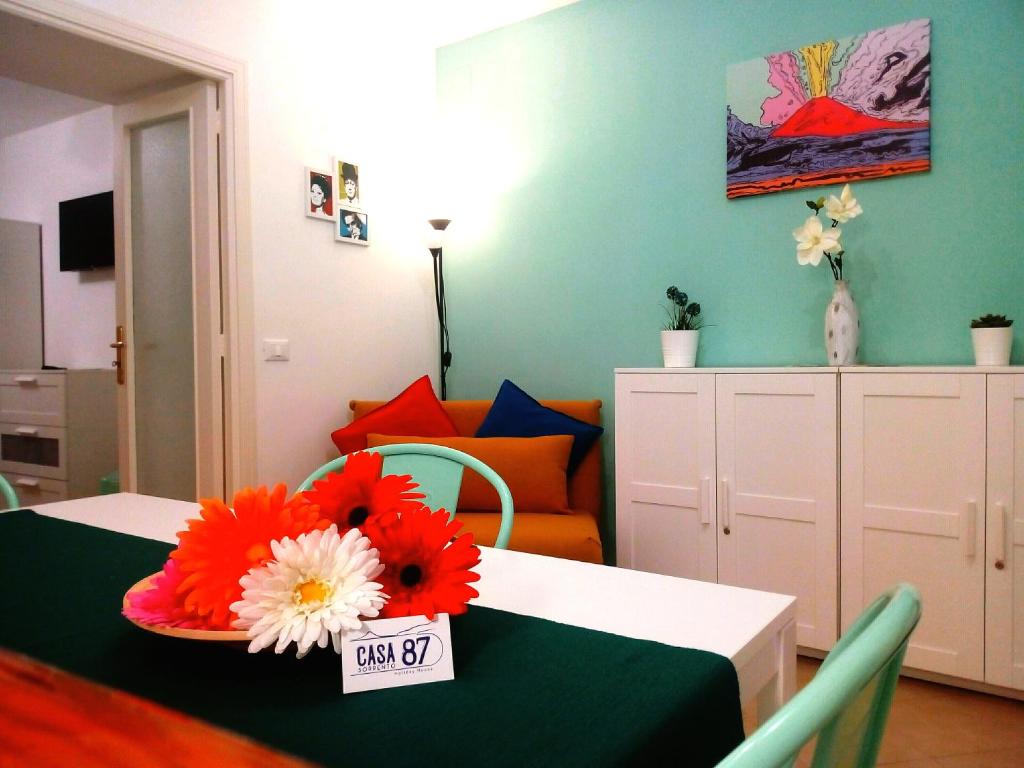 - un salon avec une table et des fleurs dans l'établissement Casa 87 - Sorrento, à Sorrente