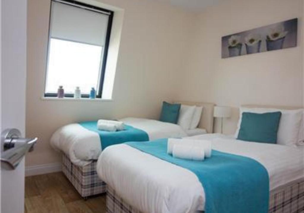 a hotel room with two beds and a window at StayZo Castle Point 18 Apartments - Premier Lodge in Southampton