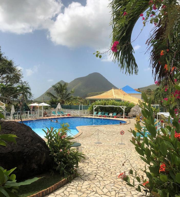 una piscina con una montagna sullo sfondo di Le Mayann a Le Diamant
