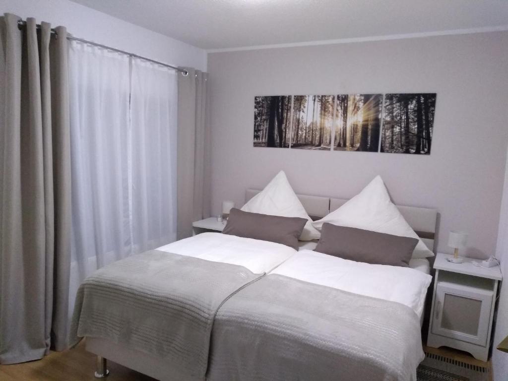 Schlafzimmer mit einem Bett mit weißer Bettwäsche und einem Fenster in der Unterkunft Ferienwohnung Altstadt in Rottenburg