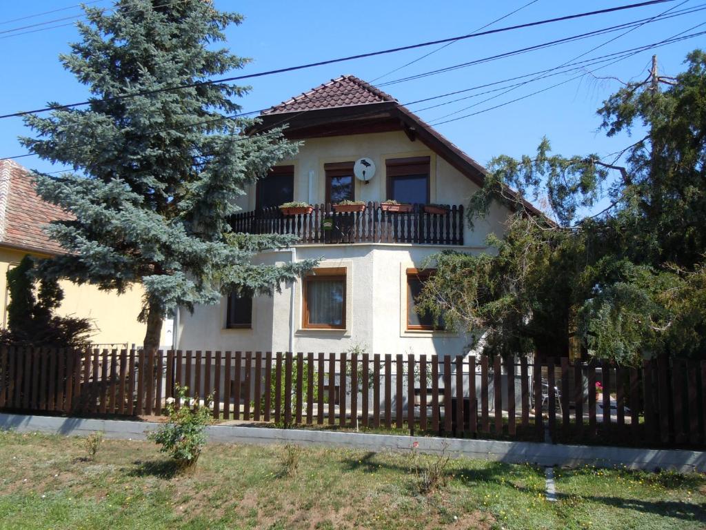 una casa blanca con una valla en apartman-kata en Fertőd