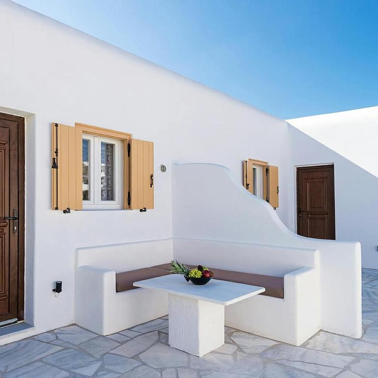a white room with a table and stairs at Ch apartment's Mykonos in Ornos