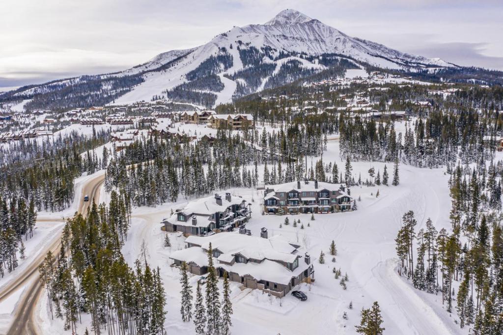 een luchtzicht op een resort in de sneeuw met een berg bij Gateway Condo - 15 Wildwood in Big Sky