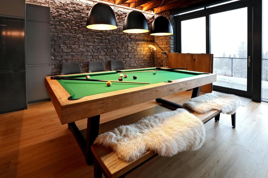 a billiard room with a pool table and a couch at Vila Relax in Donovaly