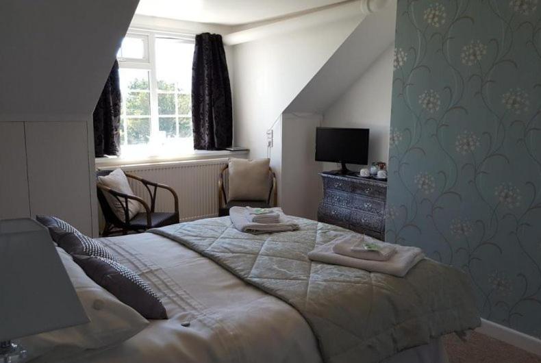 a bedroom with a large bed with two towels on it at The Balnoon Inn with rooms in St Ives
