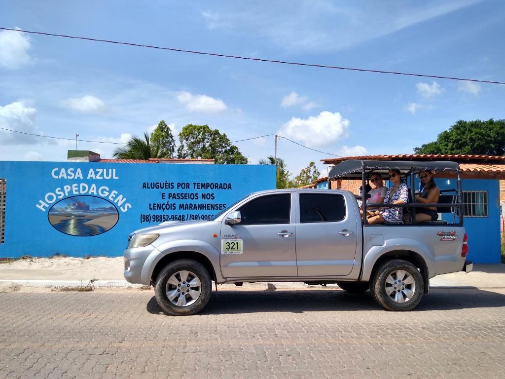 Een zilveren truck met mensen achterin. bij Casa Azul in Barreirinhas