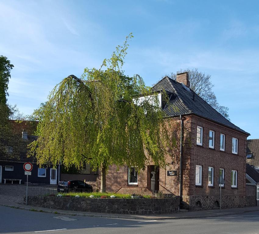 ein Baum vor einem Backsteingebäude in der Unterkunft Gästehaus bed & kitchen in Schleswig