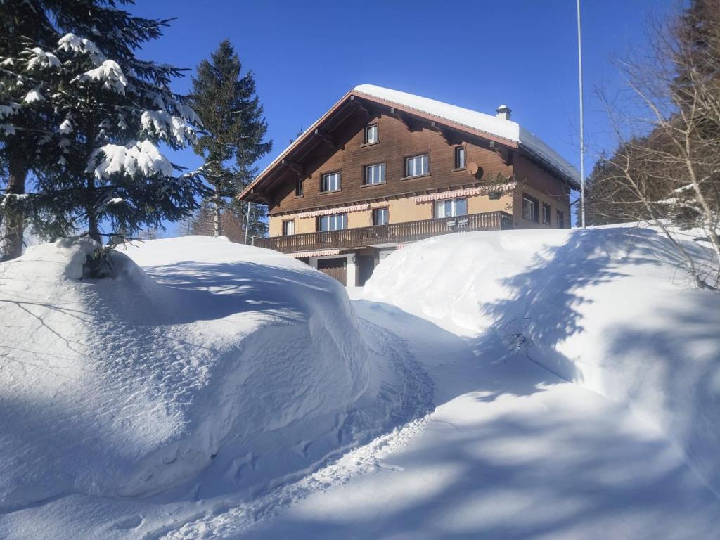 un cumulo di neve davanti a una casa di Säntisecho - in der Natur zu Hause a Urnäsch