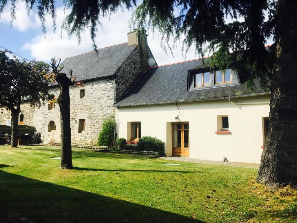 una casa blanca con un árbol en el patio en Trevejean chambre d'hotes de charme, en Guerlédan