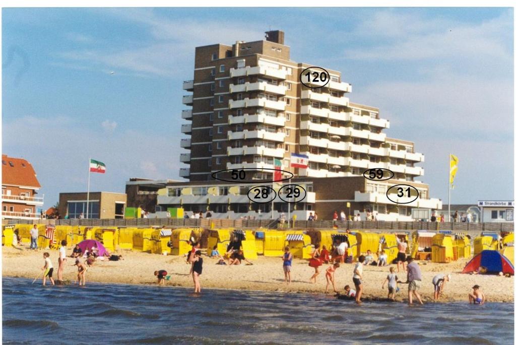 a group of people on a beach with a building at Christiansen im Panoramahaus Duhnen in Cuxhaven