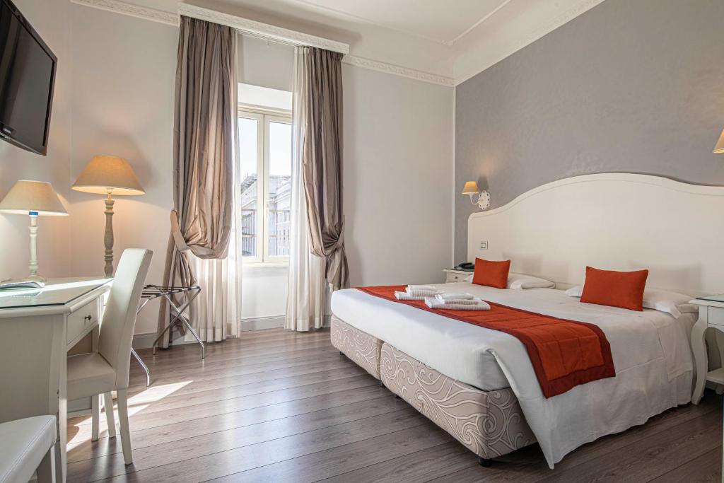 um quarto de hotel com uma cama e uma secretária em Suite Castrense em Roma