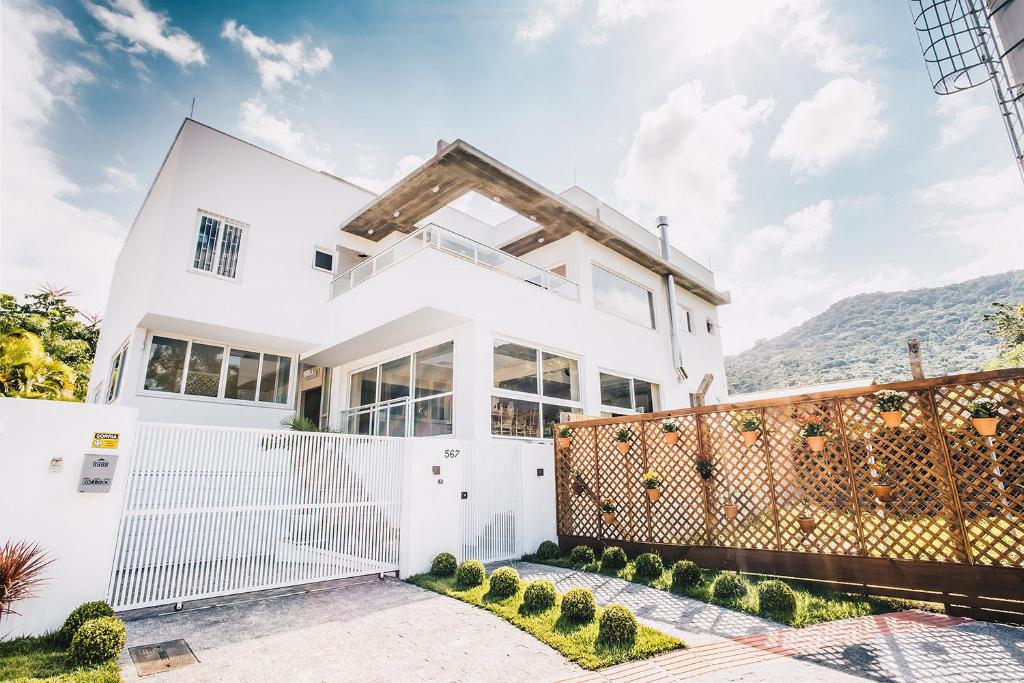 a white house with a fence at Pousada Native in Florianópolis