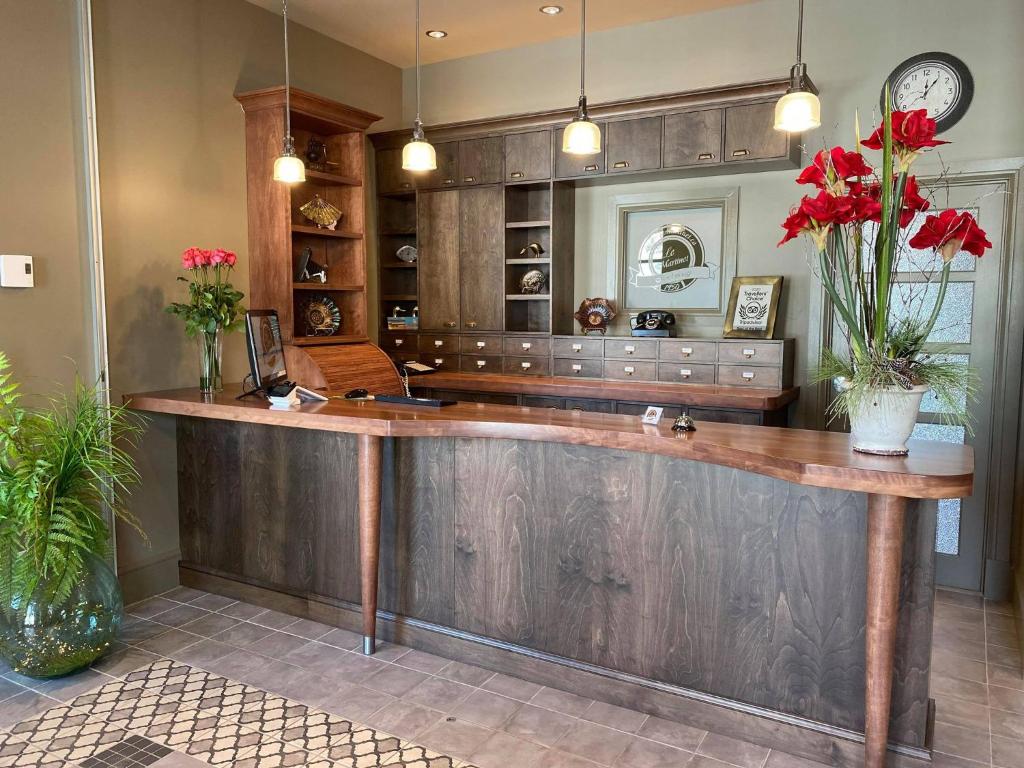 a kitchen with a large wooden counter with red flowers at Motel Le Martinet in La Pocatiere