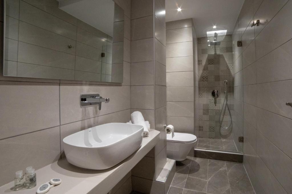 biała łazienka z umywalką i toaletą w obiekcie Aphrodite Hotel & Apartments w mieście Ios (Chora)