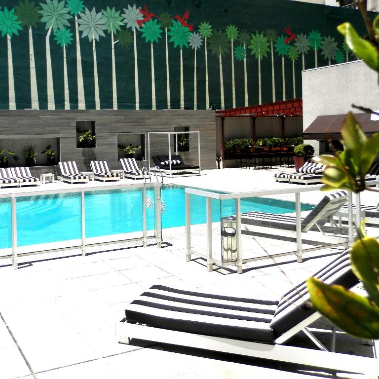 una piscina con tumbonas y una mesa y una piscina en GrandView Hotel Buenos Aires, en Buenos Aires