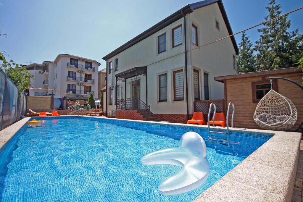 uma piscina com um golfinho branco em frente a uma casa em Золотая Миля em Anapa