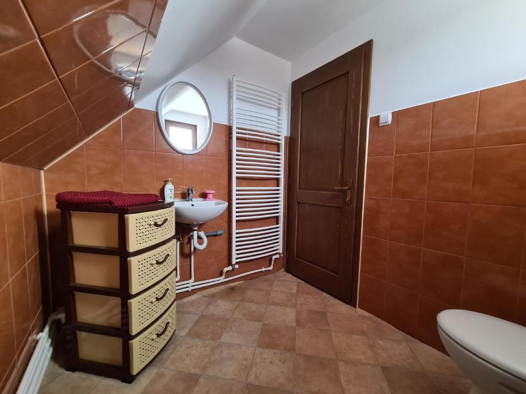 a bathroom with a toilet and a sink at Székelyvarsági Fenyves Kuckó in Vărşag