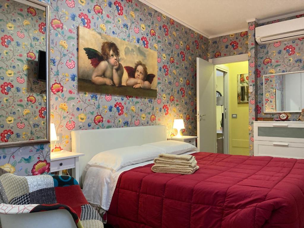 Un dormitorio con una cama roja y una pintura en la pared en B&B Paris, en Pantelleria