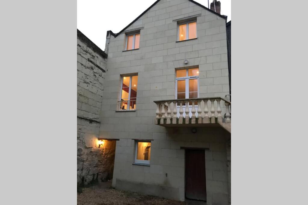 uma vista exterior de uma casa com uma varanda em Jolie maison en tuffeau dans le centre de Saumur em Saumur