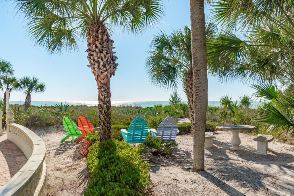 a group of chairs and palm trees on the beach at Casey Key Retreat in Nokomis