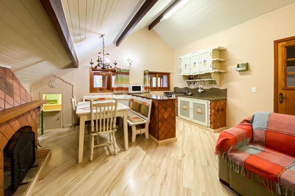 a kitchen and dining room with a table and a couch at Apart Central MV in Monte Verde