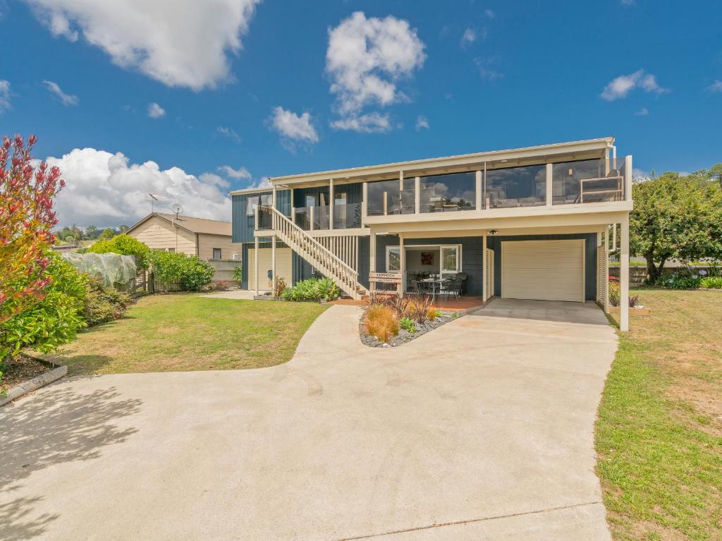 a large house with a driveway at Daze Away - Cooks Beach Holiday Home in Cooks Beach