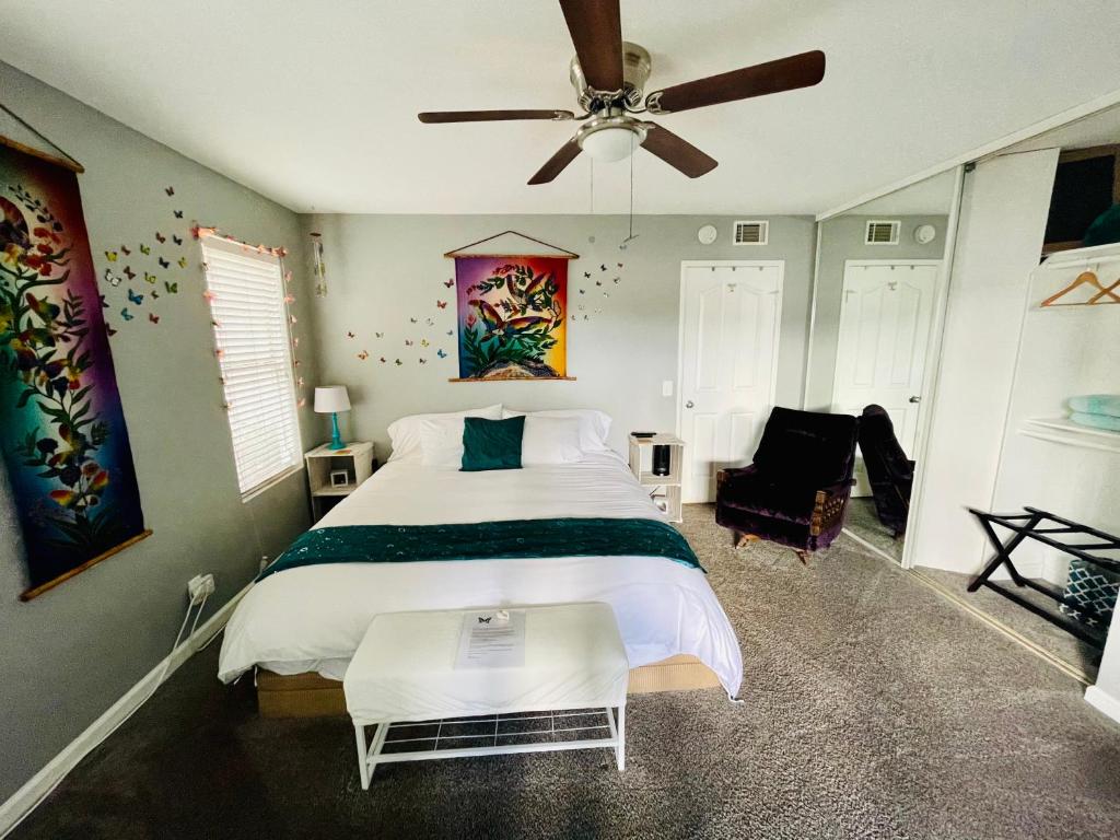 a bedroom with a large bed and a ceiling fan at Pacific Beach Butterfly Suite in San Diego