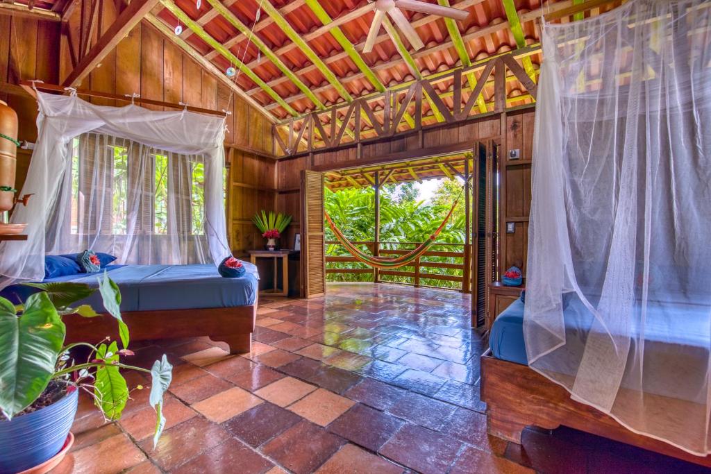 a bedroom with a bed and a door to a patio at Selva Bananito Lodge in Westfalia