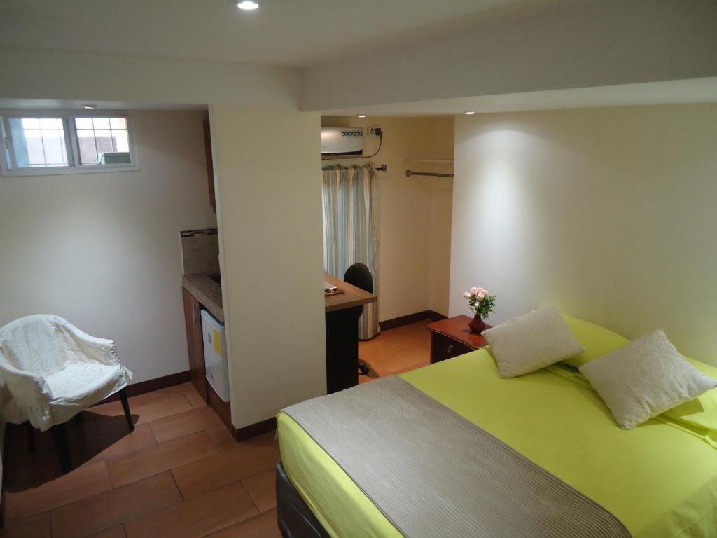 a bedroom with a bed and a desk in a room at SUITES Minimalistas in Guayaquil