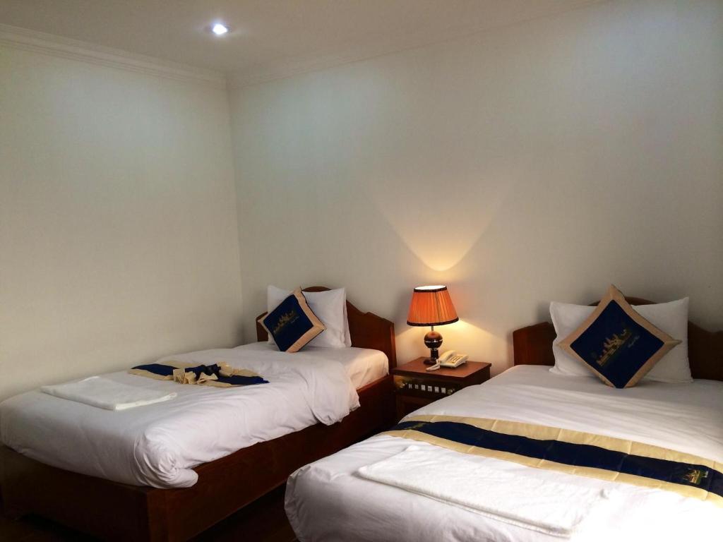 Postel nebo postele na pokoji v ubytování Emerald BB Battambang Hotel