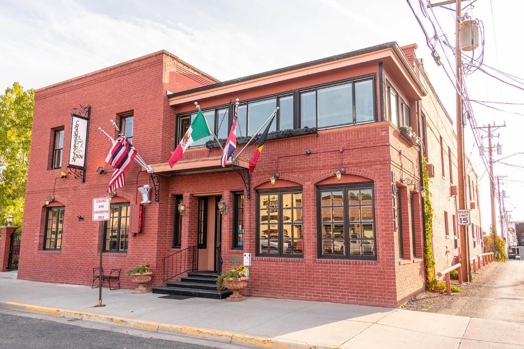 budynek z czerwonej cegły z flagami przed nim w obiekcie Chamberlin Inn w mieście Cody