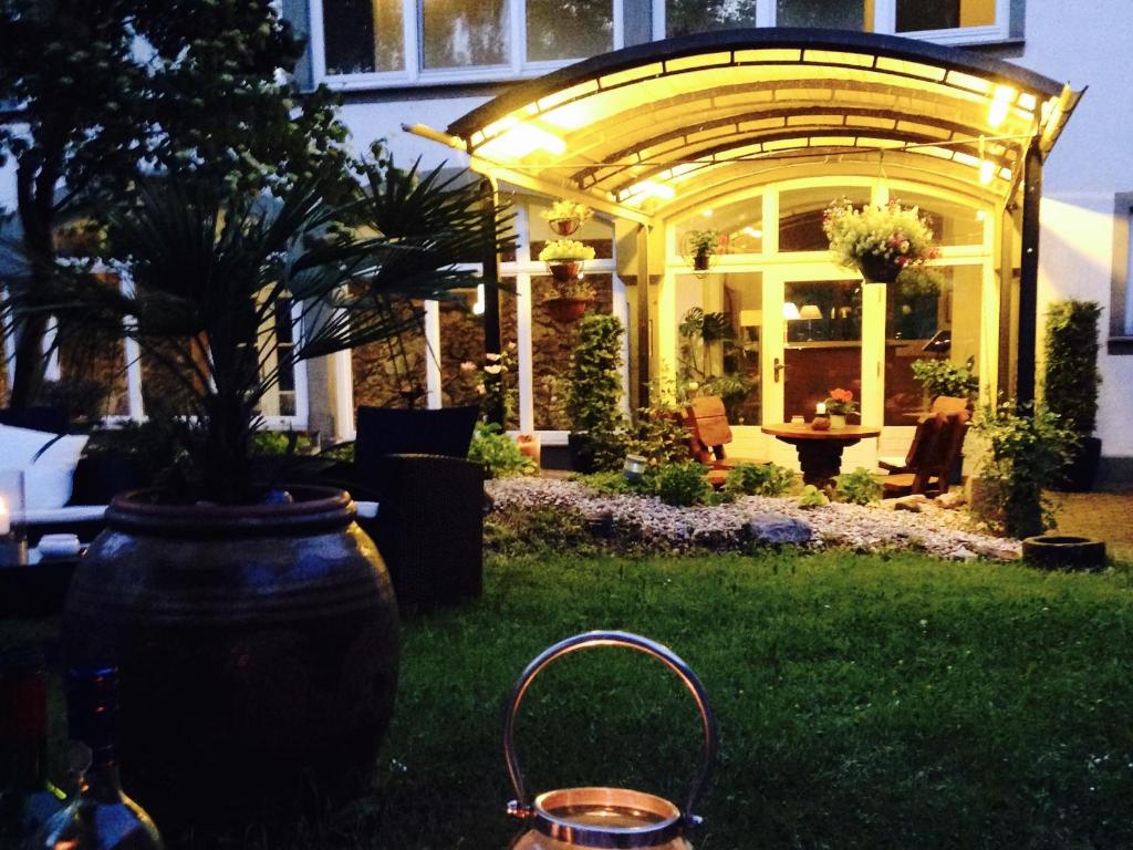 格爾利茨的住宿－Dein Gutshof Hotel & Ferienwohnungen，坐在房子院子中的一个大花瓶