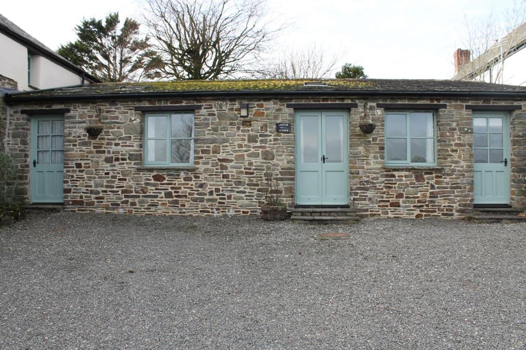 a brick building with three windows on the side of it at Lavender Cottage in Bude