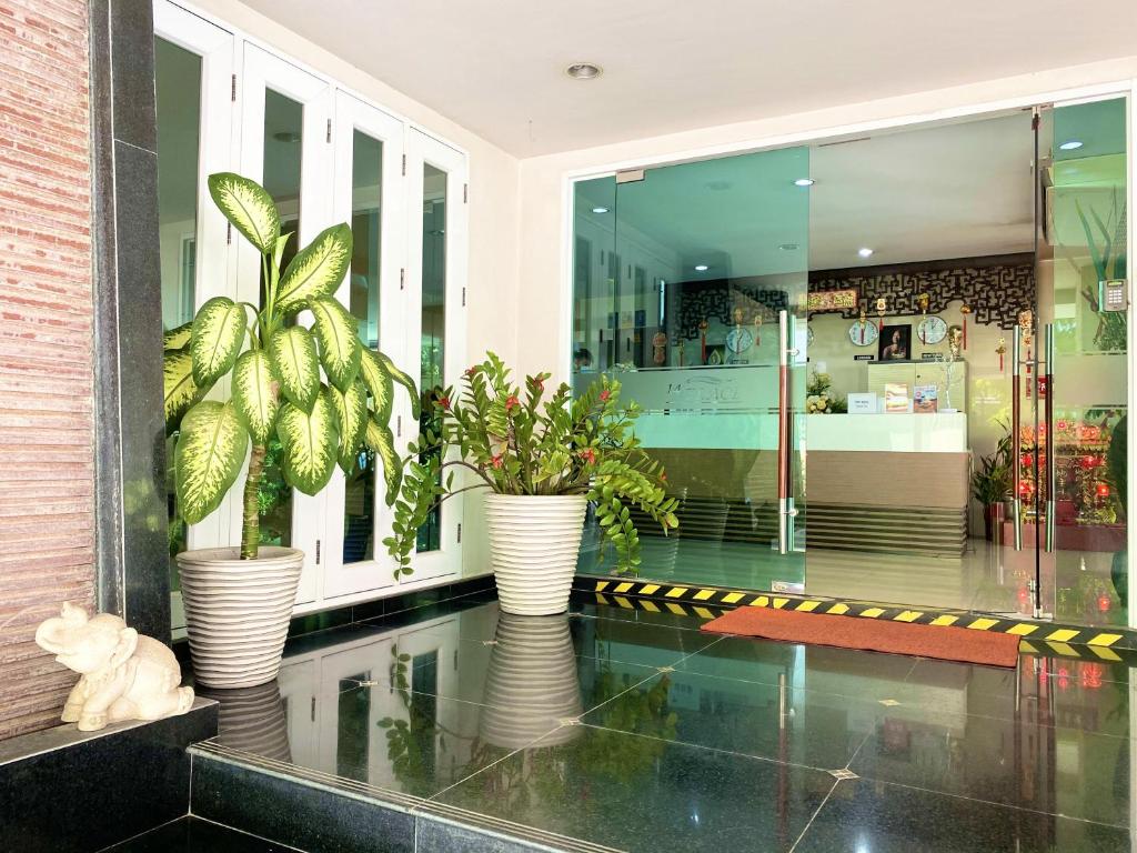 バンコクにある14 プレイス スクンビット スイーツの植物が飾られた花瓶が3本あるロビー