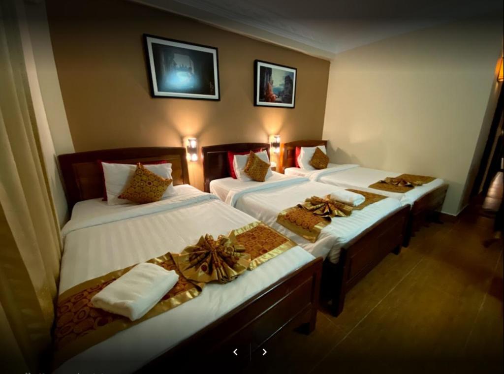 Postel nebo postele na pokoji v ubytování Angkor Pearl Hotel