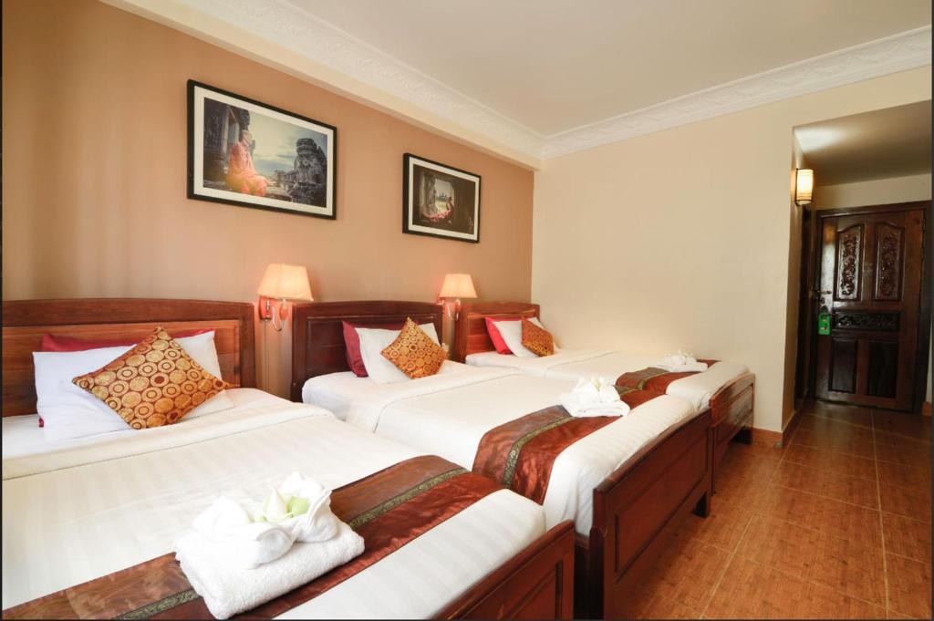 Postel nebo postele na pokoji v ubytování Angkor Pearl Hotel