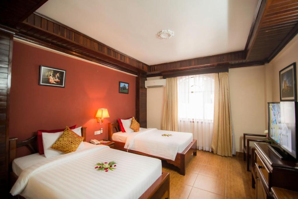 Postel nebo postele na pokoji v ubytování Angkor Pearl Hotel