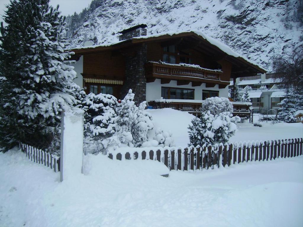 a house with a fence covered in snow at Gästehaus Waltraud in Längenfeld