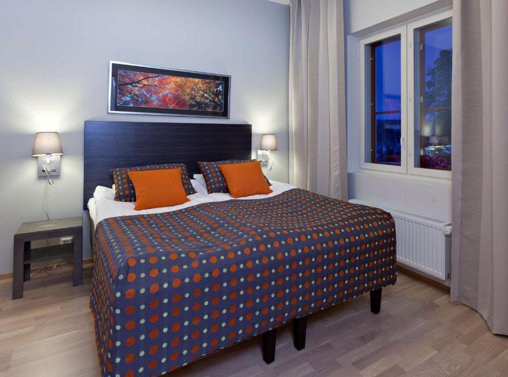 Un dormitorio con una cama grande con almohadas naranjas. en Holiday Club Saariselkä Superior Apartments, en Saariselkä