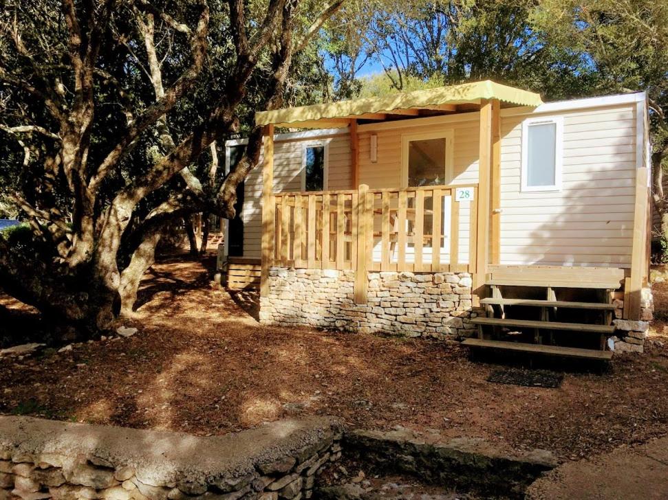 una piccola cabina con recinzione e albero di Camping Campo Di Liccia a Bonifacio