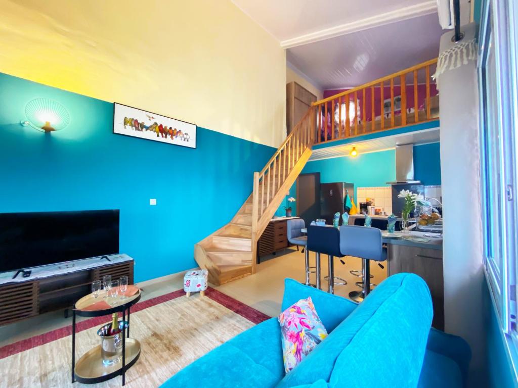 ein Wohnzimmer mit blauen Wänden und einem blauen Sofa in der Unterkunft Le Tuit-Tuit **** in Sainte-Suzanne
